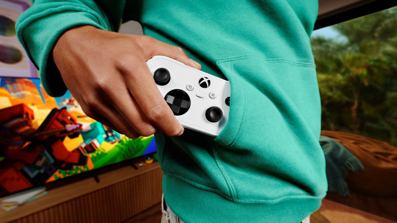 Nouvelle manette Xbox Nano blanche tenue à la main, photographiée officiellement par Microsoft